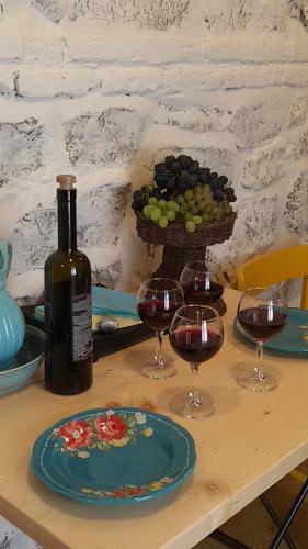 a table with two glasses of wine and a basket of grapes at Nino's House in Tsinandali