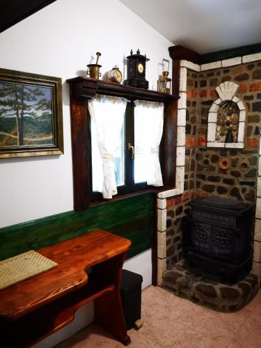 a room with a fireplace and a table and a stove at Apartments DM in Mokra Gora