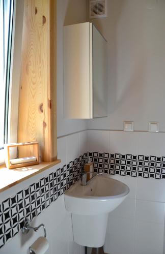 a white bathroom with a sink and a cabinet at Domek Klimaty- Kamieńczyk in Międzylesie