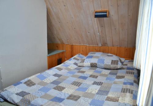 a bedroom with a bed with a quilt on it at Domek Klimaty- Kamieńczyk in Międzylesie