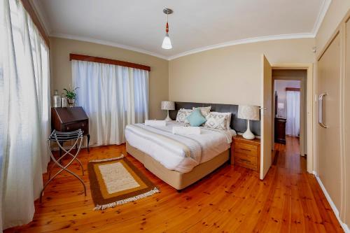 a bedroom with a large bed and a wooden floor at Munro Suites in Port Elizabeth