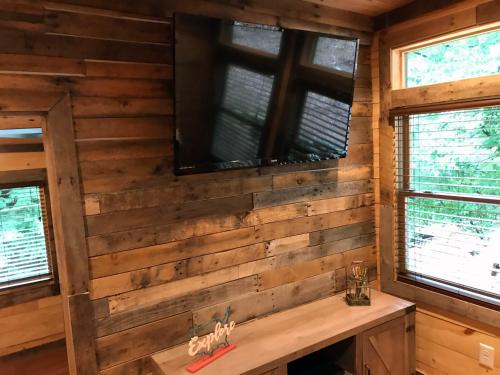Una habitación con una pared de madera con un televisor. en Art Loft, en Sevierville