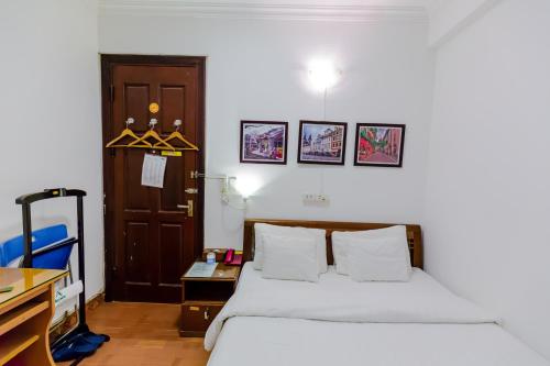 a bedroom with a bed and a desk and a door at A25 Hotel - Đội Cấn 2 in Hanoi