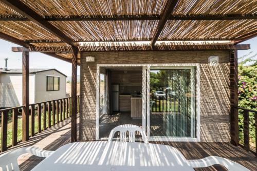a patio with a table and chairs on a deck at Camping Ermosa in Posada