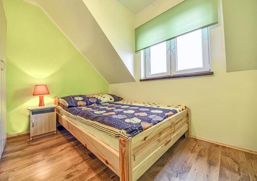 niewielka sypialnia z łóżkiem i oknem w obiekcie domki z kominkiem w Polańczyku