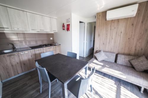 a kitchen and dining room with a table and chairs at Camping Ermosa in Posada