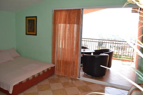 a bedroom with a bed and a balcony with a table at Apartments Milosevic in Bar