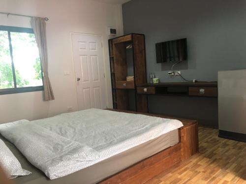 a bedroom with a bed and a dresser and a window at SP Home BangSaen in Bangsaen