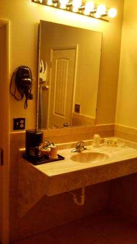 a bathroom with a sink and a large mirror at Trails End Motel Sheridan in Sheridan