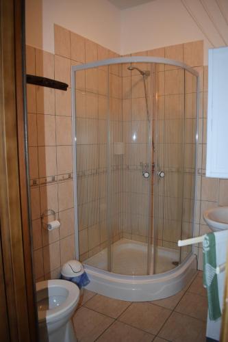 a shower stall in a bathroom with a toilet at Villa Bella Apartman in Bük