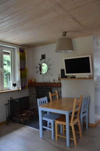 a dining room with a table and chairs and a tv at Domek Klimaty- Kamieńczyk in Międzylesie