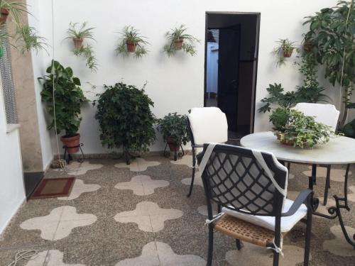 une terrasse avec une table, des chaises et des plantes en pot dans l'établissement Casa del Agüista, à Marmolejo