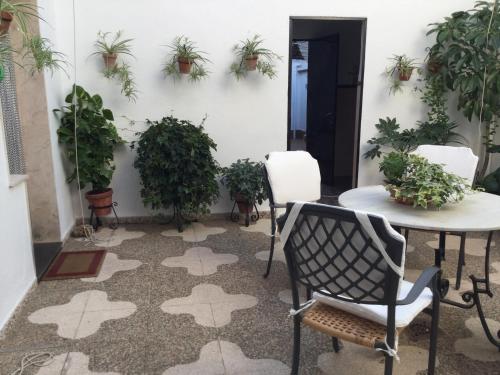 Casa del Agüista في مارموليخو: فناء مع طاولة وكراسي والنباتات الفخارية