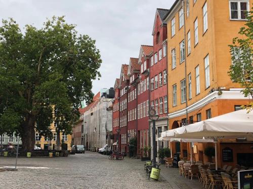 a city street with tables and chairs and buildings at K10 Apartments in Copenhagen