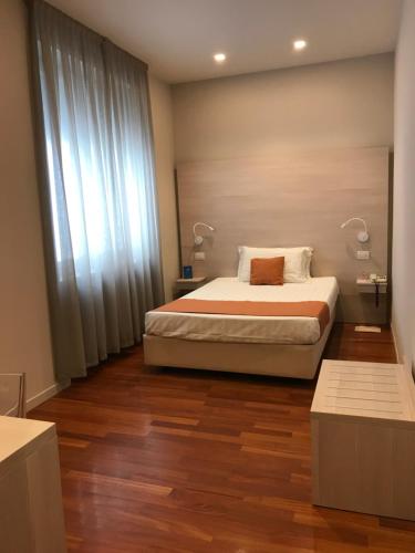 sypialnia z łóżkiem i 2 lampkami na drewnianej podłodze w obiekcie Albergo Anelli w mieście Lodi