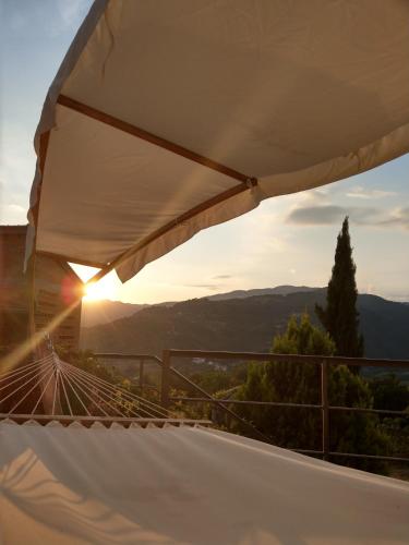 a hammock on a balcony with the sunset in the background at Agriturismo La Fontaccia in Rufina