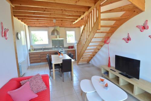 un salon avec un canapé rouge et une cuisine dans l'établissement Roche Blanche 2, à Saint-Lunaire