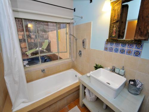 a bathroom with a white tub and a sink at Love & Lemons in Yesod Hamaala