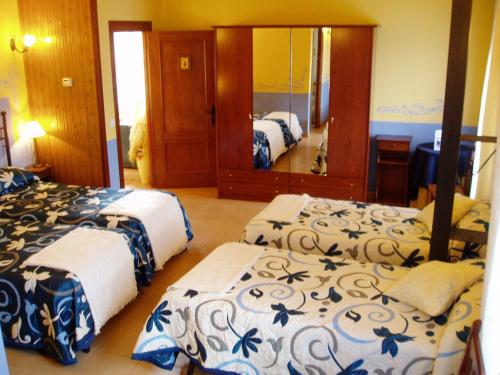 a hotel room with two beds and a mirror at La Casa del Filandón- HOTEL RURAL in Quintanilla de Somoza