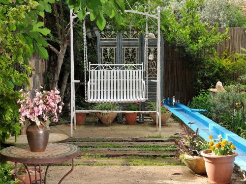 a swing in a garden with plants and flowers at Love & Lemons in Yesod Hamaala