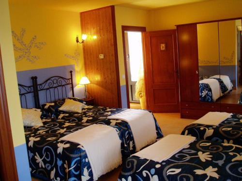 a bedroom with two beds and a mirror at La Casa del Filandón- HOTEL RURAL in Quintanilla de Somoza