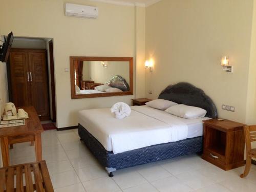 Un pat sau paturi într-o cameră la Astina Hotel
