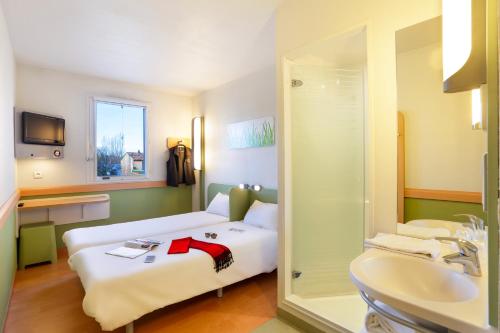 a hotel room with a bed and a sink at Ibis Budget Vélizy in Vélizy-Villacoublay