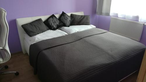 a bedroom with a large bed with black and white pillows at Big Apartment 291 - Rezidence Eliska Prague 9 in Prague