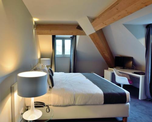 a bedroom with a bed and a desk with a lamp at Hotel Retro in Brussels