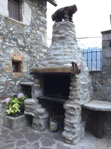 un horno de piedra con un banco delante de él en Casa Ramón La Caseta, en Sin