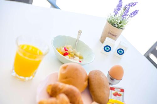 a table with a plate of food and a bowl of fruit at Madison Boutique, Faliraki in Faliraki