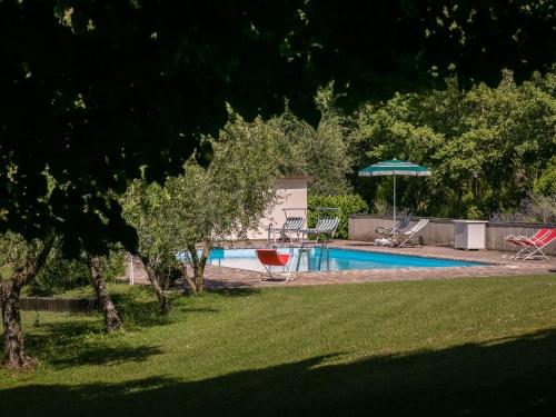 einen Pool mit einem Tisch und einem Sonnenschirm in der Unterkunft Belvilla by OYO Giardino delle Giare in Castiglion Fiorentino