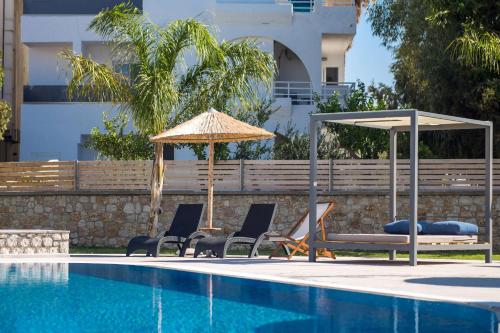 a group of chairs and an umbrella next to a swimming pool at Madison Boutique, Faliraki in Faliraki