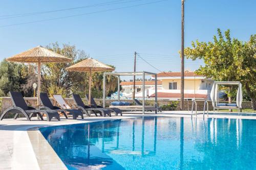 a swimming pool with chairs and umbrellas next to a swimming pool at Madison Boutique, Faliraki in Faliraki