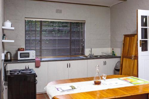 a kitchen with a wooden table and a microwave at 273 Jan Van Riebeeck in Oudtshoorn
