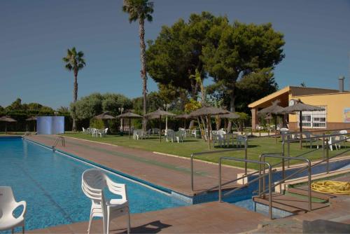 a swimming pool with chairs and tables and umbrellas at Casa con terraza in Dehesa de Campoamor