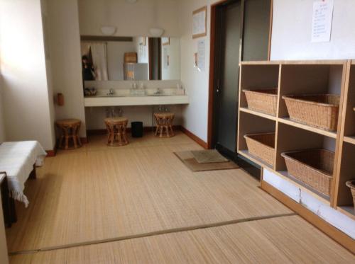 a room with a hallway with shelves and a table at Bergtour Marukita in Hakuba