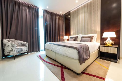 - une chambre avec un grand lit et une chaise dans l'établissement DAMAC Upper Crest in Downtown, à Dubaï