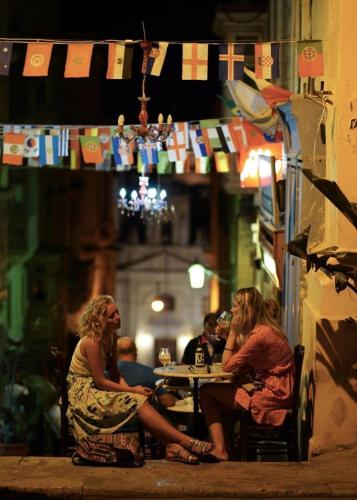 two women sitting at a table in a restaurant at Valletta Harbour View Apartment in Valletta