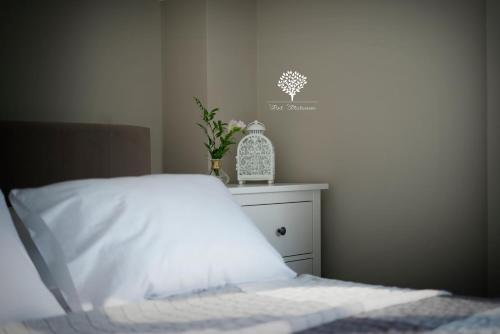 a bedroom with a bed with white sheets and a vase of flowers at Szafirowy Dwór Hotel & Restauracja in Gliwice