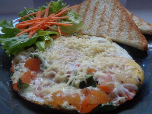 Un plato de comida con queso y verduras y tostadas. en Setilas Bungalows, en Nusa Penida