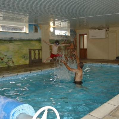 two young boys playing in a swimming pool at Forge Cottage in Merton
