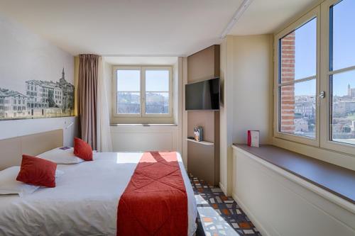 a hotel room with a bed and two windows at Mercure Albi Rives du Tarn in Albi