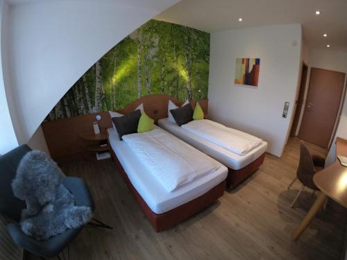 a bedroom with two beds and a painting on the wall at Hotel Landgasthaus Schäferhof in Alsfeld