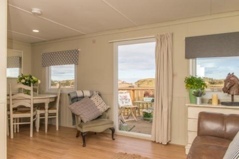 ein Wohnzimmer mit einem Tisch und einem Esszimmer in der Unterkunft Estuary View Caravans in Alnmouth