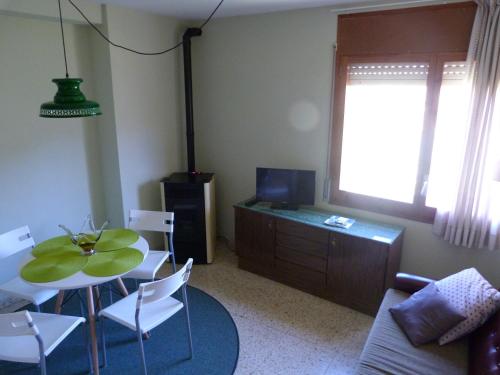 uma sala de estar com uma mesa e cadeiras e uma televisão em Ca la Pagesa em San Lorenzo de Morunys