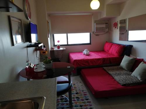a living room with a red couch and a table at Nica's Place Property Management Services at Horizons 101 Condominium in Cebu City
