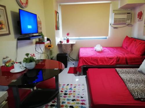 a living room with a red couch and a table at Nica's Place Property Management Services at Horizons 101 Condominium in Cebu City