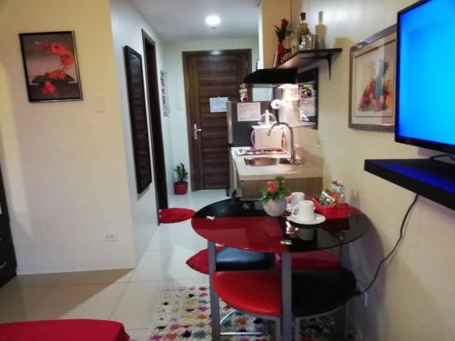 a living room with a table and a television at Nica's Place Property Management Services at Horizons 101 Condominium in Cebu City