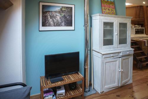 a living room with a tv and a hutch at Grand studio duplex proche de la mer in Fécamp